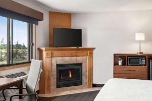 a hotel room with a fireplace and a flat screen tv at AmericInn by Wyndham Baudette in Baudette