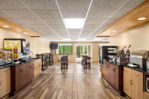 a lobby with a cafeteria with tables and chairs at AmericInn by Wyndham Baudette in Baudette