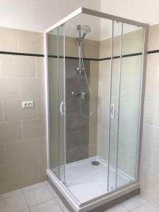 La salle de bains est pourvue d'une douche avec une porte en verre. dans l'établissement Haut de maison entièrement rénové avec garage, à Carnoux-en-Provence