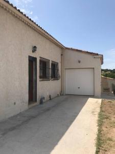 un grand bâtiment blanc avec un garage dans l'établissement Haut de maison entièrement rénové avec garage, à Carnoux-en-Provence