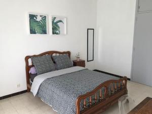 - une chambre avec un lit en bois et des oreillers dans l'établissement Haut de maison entièrement rénové avec garage, à Carnoux-en-Provence