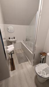 uma casa de banho branca com um WC e um lavatório em Lovely 2 Bedroom Apartment in Central Location em Greenock