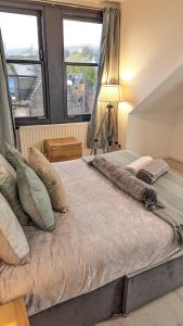 2 camas en un dormitorio con 2 ventanas en Lovely 2 Bedroom Apartment in Central Location, en Greenock