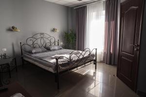 um quarto com uma cama num quarto com uma janela em Ermitazh Hotel Complex em Novomoskovsk
