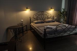 ein Schlafzimmer mit einem Bett mit zwei Kissen und einem Tisch in der Unterkunft Ermitazh Hotel Complex in Nowomoskowsk