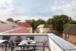 einen Balkon mit einem Tisch und Stühlen auf dem Dach in der Unterkunft Pension Schlossgasse in Lieberose