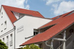 ein Gebäude mit rotem Dach in der Unterkunft Pension Schlossgasse in Lieberose