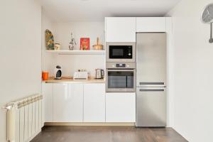 a white kitchen with a refrigerator and a microwave at Alojamiento centro historico Catedral in Salamanca