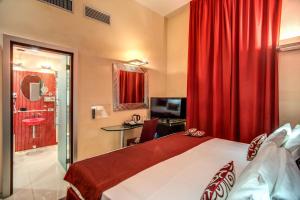 um quarto de hotel com uma cama e uma cortina vermelha em Rome Easy Rooms em Roma