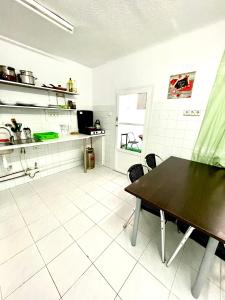 a kitchen with a black table and a white tiled floor at Las habitaciones de Svetlana in Alicante