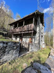 una vieja casa de piedra en una colina en el bosque en Chalet Baita Magugnaga, en Ceppo Morelli