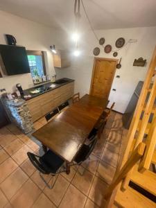 a kitchen with a wooden table with chairs and a sink at Chalet Baita Magugnaga in Ceppo Morelli