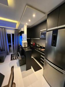 a kitchen with a stainless steel refrigerator in a room at brisas da maré in Passo de Torres