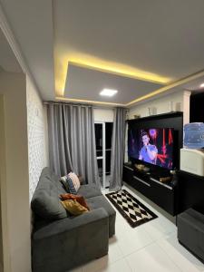 een woonkamer met een bank en een flatscreen-tv bij brisas da maré in Passo de Torres