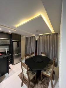 a dining room with a black table and chairs at brisas da maré in Passo de Torres +6 photos