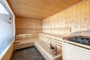 a sauna with wooden walls and benches in a room at Zugspitz Residence Ehrwald in Ehrwald
