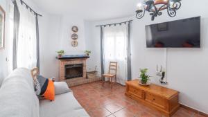 ein Wohnzimmer mit einem Sofa und einem Kamin in der Unterkunft Casa Moreno Cómpeta by Ruralidays in Cómpeta