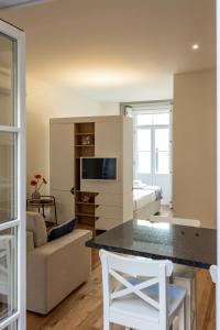 a living room with a kitchen and a room with a bed at Bright studio with terrace in Porto