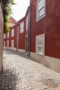 une rue pavée en face d'un bâtiment rouge dans l'établissement Bright studio with terrace, à Porto