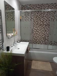 La salle de bains est pourvue d'une douche, d'un lavabo et d'une baignoire. dans l'établissement Charme et confort au cœur de Graça, à Lisbonne