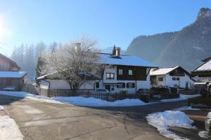een huis met sneeuw aan de kant van een straat bij Wohnung Bergtraum inmitten der Ammergauer Alpen in Oberammergau