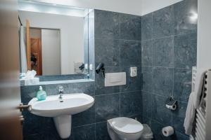 uma casa de banho com um lavatório, um WC e um espelho. em Hotel & Gastro Adler GmbH em Itzehoe