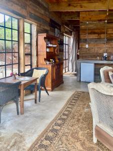 ein Wohnzimmer mit einem Tisch und Stühlen in der Unterkunft Rose Mountain Cottage in Nottingham Road