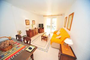 a living room with a yellow couch and a table at CALA GONZÁLEZ Orange Costa in Alcossebre