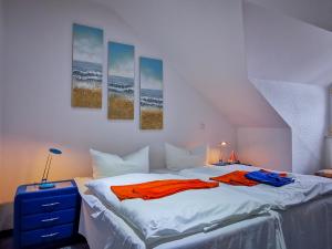 a bedroom with a bed with three paintings on the wall at Feriendomizil Binz in Binz +61 photos