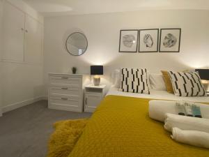 a bedroom with a large bed with a yellow blanket at Lilypad A central location to explore the New Forest & South Coast in Ringwood