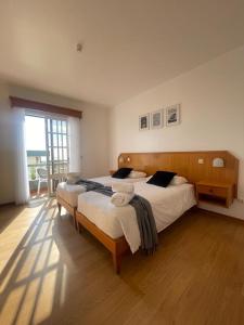 sypialnia z 2 łóżkami i dużym oknem w obiekcie Valhalla Panorama - the old Residencial Pina w Funchal