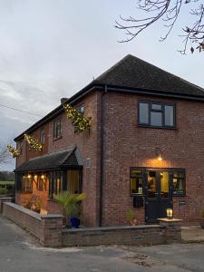 a brick house with a black door and windows at Marshpools Bed & Breakfast - Licensed near Weobley village in Weobley