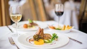 a table with two plates of food and glasses of wine at The Imperial Hotel in Barnstaple