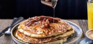 a stack of pancakes on a plate with syrup at BrewDog DogHouse Edinburgh in Edinburgh