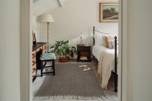 a bedroom with a bed and a rug at The Stables - Charming 15th-century rural bolthole in Newton Abbot