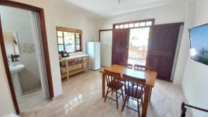 a kitchen and dining room with a table and chairs at Nossa Guarda Acomodações in Guarda do Embaú