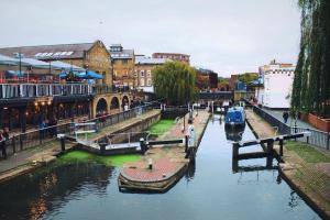 einen Kanal in einer Stadt mit einem Boot im Wasser in der Unterkunft The Wesley Camden Town in London