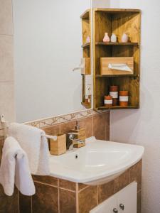 bagno con lavandino bianco e specchio di A MI KISHÁZUNK vendégház a Szomód
