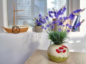 Eine Vase mit Blumen auf einem Tisch in der Unterkunft Apartment AMAPOLA - Villa Odin in Ostseebad Sellin