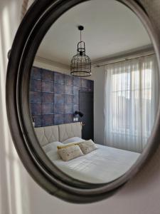 um espelho que reflecte uma cama num quarto em Hipster suites - Chez Axelle - em Colmar