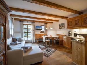 eine Küche und ein Wohnzimmer mit einem Sofa und einem Tisch in der Unterkunft Landhaus Ammer in Oberndorf in Tirol