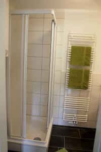 ヘリングスドルフにあるVilla Bergfriedのバスルーム(シャワー、緑のタオル付)