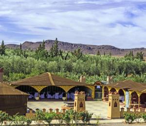 a view of a resort with mountains in the background at Dar Alfourssane Ferme d’hôte in Ouarzazate