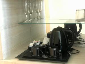 a coffee maker and wine glasses on a counter at Hotel Neptuno Playa & Spa in Valencia