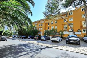 a row of cars parked in front of a building at Tropical Pool View Cascais - Checkinhome in Cascais