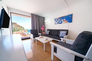 a living room with a couch and a table at Apartamentos Río Piedras in Puerto Rico de Gran Canaria