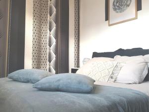 1 dormitorio con 1 cama con 2 almohadas en Cosy flat proche Gare & Parking - clim, en Agen