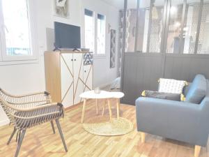 sala de estar con sofá, silla y mesa en Cosy flat proche Gare & Parking - clim, en Agen