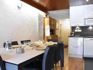 a dining room table with chairs and a kitchen at Appartement cosy 8 pers. Méribel Centre, proche pistes, internet inclus - FR-1-180-184 in Méribel