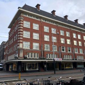 um grande edifício de tijolos vermelhos com bicicletas estacionadas em frente em Amigo Hotel em Amsterdã